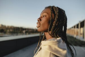 African young woman with dreadlocks, in profile contemplating the city.